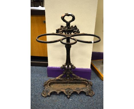 A COALBROOKDALE STYLE CAST IRON TWO DIVISION STICK STAND, painted black with scroll and floral mounts to shaped base, oval dr