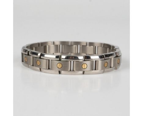 This modernistic bracelet features titanium links set with 14k yellow gold and a stainless steel clasp. It comes in a box tha