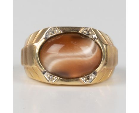 This bold ring features a 10k gold band set with a beautiful oval cat's eye stone and four diamonds. 10K stamp inside the ban