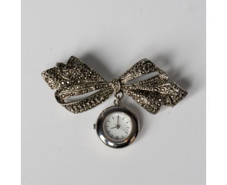 Beautiful silver tone bow brooch with a stainless steel dangling clock face. It comes in its original box which measures 4"L 