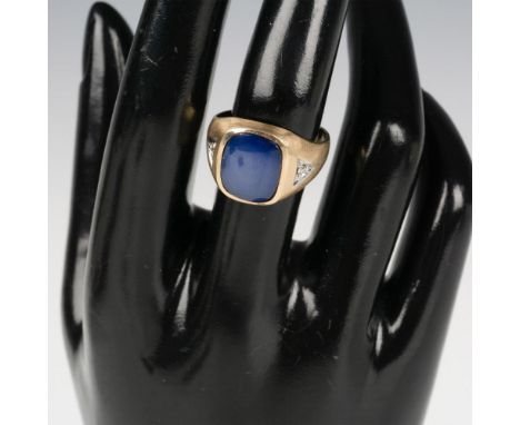 This stunning ring features a blue star sapphire center stone with a small diamond on either side. Marked 10k inside the band