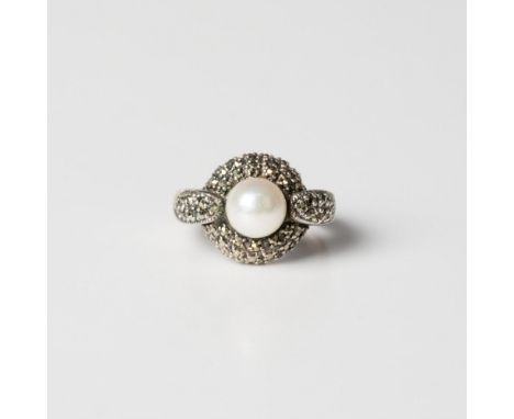 This gorgeous ring is marked sterling silver. It is set with a large genuine pearl in the center surrounded by small marcasit