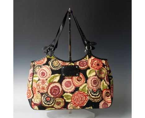 Black canvas tote decorated with round, red flowers. Black leather straps and bottom. Magnetic closure with gold fabric linin