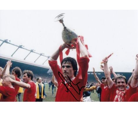 Football Autographed ALAN HANSEN photo, a superb image depicting the Liverpool centre-half holding aloft the League Champions