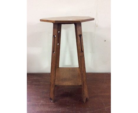 An Arts &amp; Crafts light oak octagonal top occasional table on rectangular outward legs united with a square shelf.