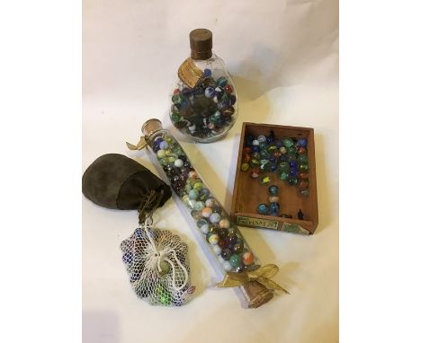 A collection of assorted marbles in a glass rolling pin , a Dimple bottle,&nbsp; in a tin,&nbsp; and some in a wooden box (4)