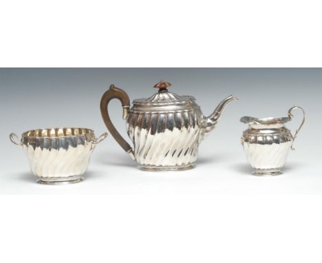 A Victorian silver three-piece wrythen-fluted ogee tea service, comprising teapot, milk jug and sugar basin, the teaput with 