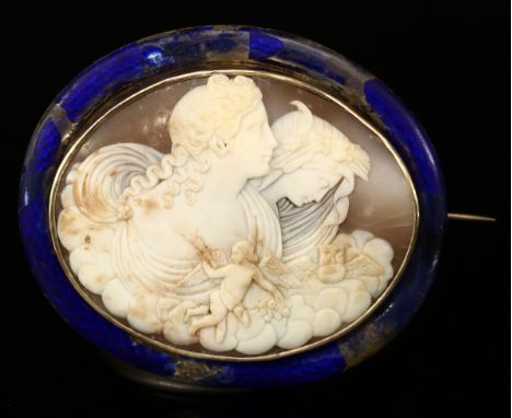 A Victorian oval shell cameo brooch, carved in relief with female classical profiles, within styalised clouds and a winged Pu