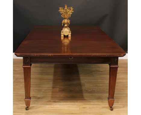 A late Victorian mahogany extending dining table, rounded rectangular top with two additional leaves, the mechanism applied w