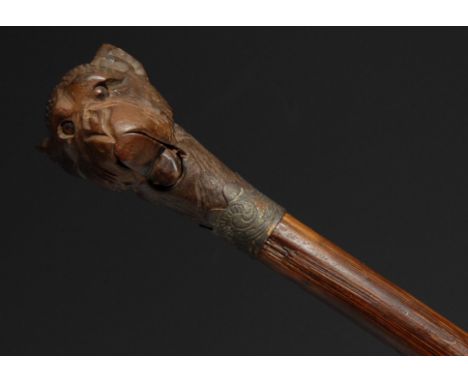 An early 20th century novelty automaton walking stick, the Black Forest type pommel carved as the head of a monkey, his lower