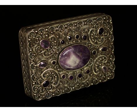 A continental silver coloured metal and amethyst rounded rectangular case, the cover set with central oval cabochon panel wit