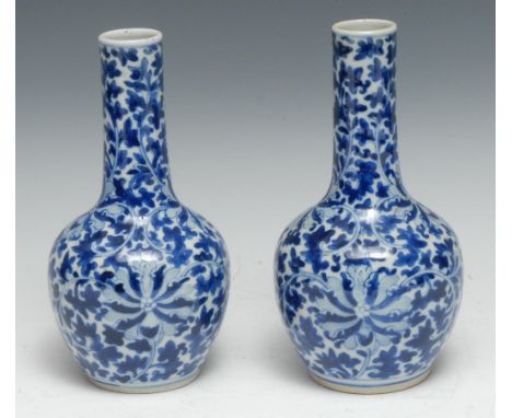 A pair of Chinese bottle vases, decorated overall with scrolling lotus and foliage, 21cm high, four character Kangxi marks 