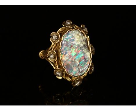 A Victorian rough cut opal and diamond ring, the large shaped oval stone set within eight stylised flowerheads, centred with 