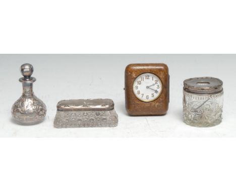 A George V silver mounted hair pin tidy, 6.5cm high, Birmingham 1925; a silver overlaid scent bottle; a travelling clock; ano