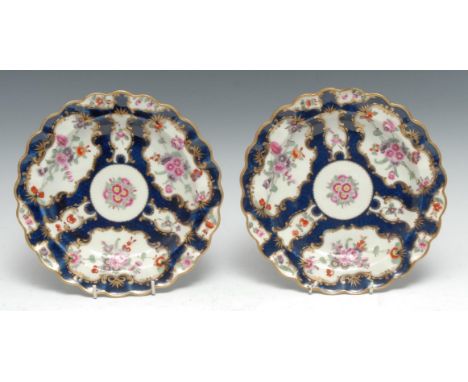 A pair of Worcester shaped circular plates, decorated with alternating fan and vase shaped reserves, each with summer flowers