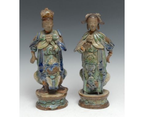 A pair of Chinese stoneware figures, of Immortals, each dressed in the Archaic taste, crackle-glazed and picked-out in tones 