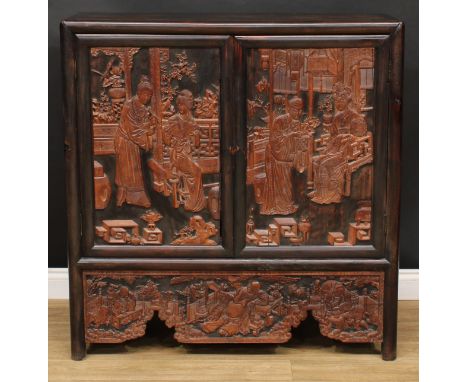 A Chinese hardwood side cabinet, flush rectangular top above a pair of panel doors carved and applied with ladies of the cour