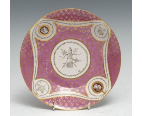 A Chelsea Derby saucer dish, painted in monochrome with military trophies to centre and four oval reserves conforming and alt