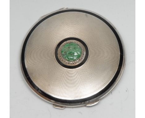 An Art Deco Chinese jade mounted silver and enamel circular powder compact, engine turned, gilt interior, 8cm diam, London 19