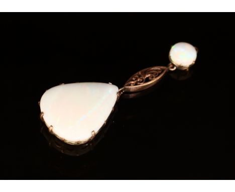 An Art Nouveau style opal teardrop pendant, claw set, suspended by a navette open scroll work gold coloured metal link and fu