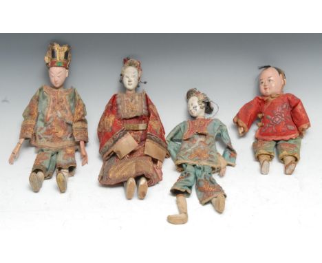 A 19th century Chinese doll, the wooden heads and limbs,  painted, wearing embroidered robes, 26cm long;  others (4) 