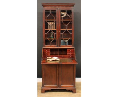 A George III mahogany bureau bookcase, dentil cornice above a blind fretwork frieze and a pair of astragal glazed doors enclo