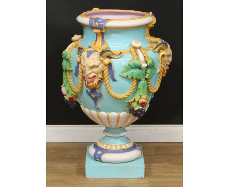 A large Minton Majolica pedestal ovoid vase, in relief with garlands of of fruit and foliage, suspended from satyr masks on a