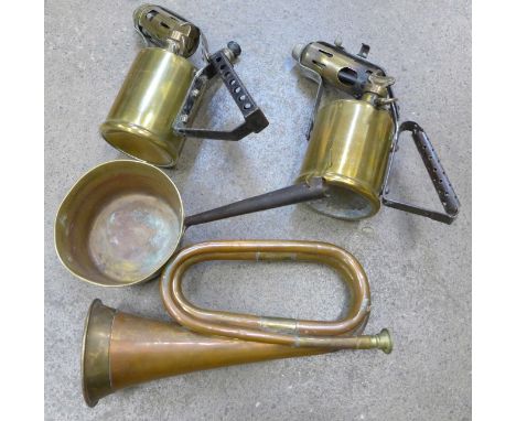 A bugle, two blow lamps and a brass pan