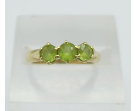 A 9ct gold and three stone peridot ring, 3.3g, N