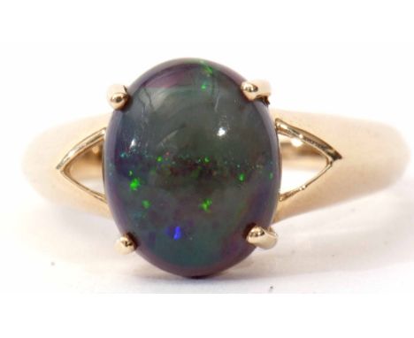 Modern single opal doublet ring, the cabochon four claw set and raised between angular pierced shoulders to a plain polished 