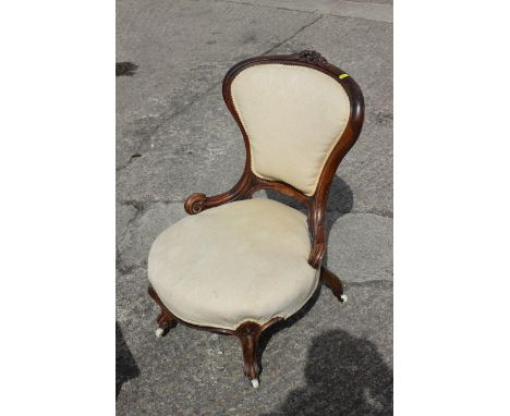 A late Victorian showframe low seat armchair, button upholstered in a green velour, on cabriole castored supports 