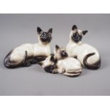 Two Beswick model Siamese cats and another similar (one damaged)