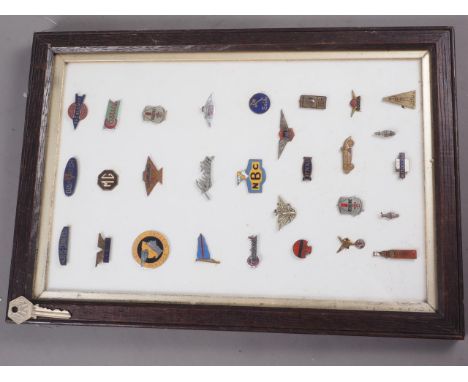 A quantity of vintage and later enamel and metal car and other related badges, various, in oak glass fronted display case, 17