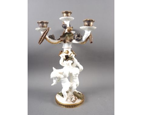 A 19th century Moores three-branch four-light candelabrum of cherub and floral design with gilt borders, on a circular base w
