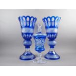A pair of Bohemian blue overlaid cut glass vases, on circular bases, 19 3/4" high and a similar vase