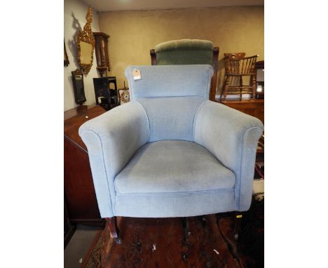 An Edwardian armchair, button upholstered in a pale blue Dralon, on castored supports, and a carved showframe armchair, on tu
