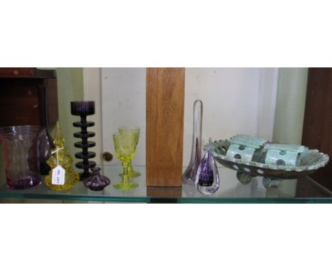 A shelf full of decorative coloured glassware, together with three items of Austrian designed pottery 