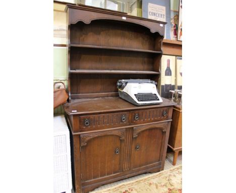 A reproduction oak finish dresser, having twin shelf plate rack back the base having two in-line drawers over two cupboard do