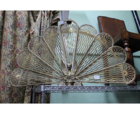 A brass peacock tail design fire screen 