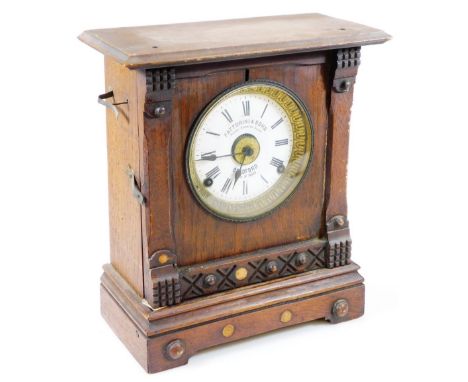 Fattorini. An early  20thC oak cased alarm mantel clock, the shaped case with raised beading on a shaped base with bracket fe