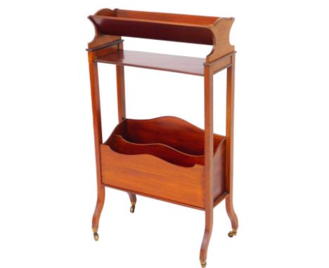 An Edwardian mahogany freestanding book trough, with shaped section raised above two sections beneath on shaped legs terminat