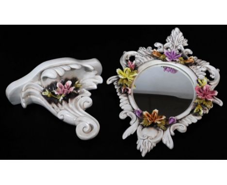 A 1970's Capodimonte mirror, of oval form, elaborately decorated and raised with flowers with a sconce scroll shelf, 32cm hig