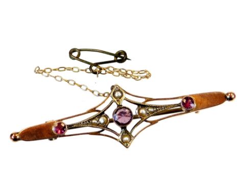 An Edwardian brooch, of shaped form with a triangular centre set with seed pearls, and three amethyst coloured stones with a 