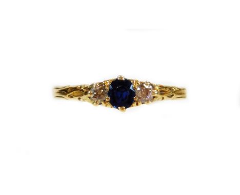 A 18ct gold dress ring, claw set with a central blue stone flanked by small diamonds, on a textured shank, size S, 2.2g all i