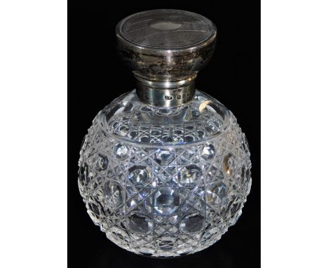 An early 20thC cut glass perfume bottle, with engine turned silver lid, 10cm high.