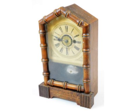 An early 20thC pine cased alarm clock, with turreted top and quarter bamboo finish front revealing a 11cm wide plate with Rom