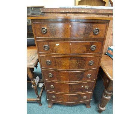 An Edwardian mahogany tallboy bow front chest of six drawers raised on splay bracket feet.