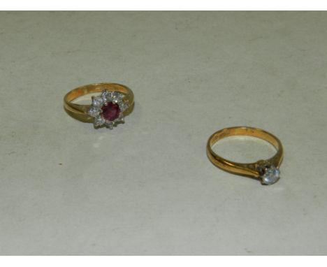 An 18ct gold ruby and diamond floral cluster ring, designed a central round mixed cut ruby with in a surround of 8 brilliant 