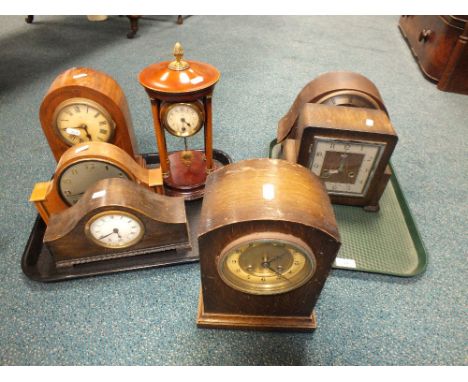 Three early 20th century oak cased mantle clocks, an Edwardian inlaid mahogany mantle clock, a mahogany portico type clock an