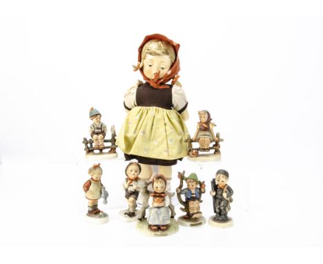 A Goebels Hummel porcelain headed doll, with moulded fly-away hair, stuffed body, porcelain limbs and original clothes --14in
